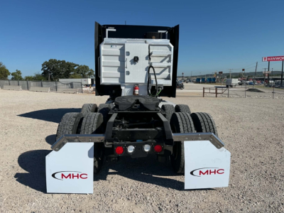 Kenworth T680 rear view showing fifth wheel area and dual rear mud flaps with MHC logos.