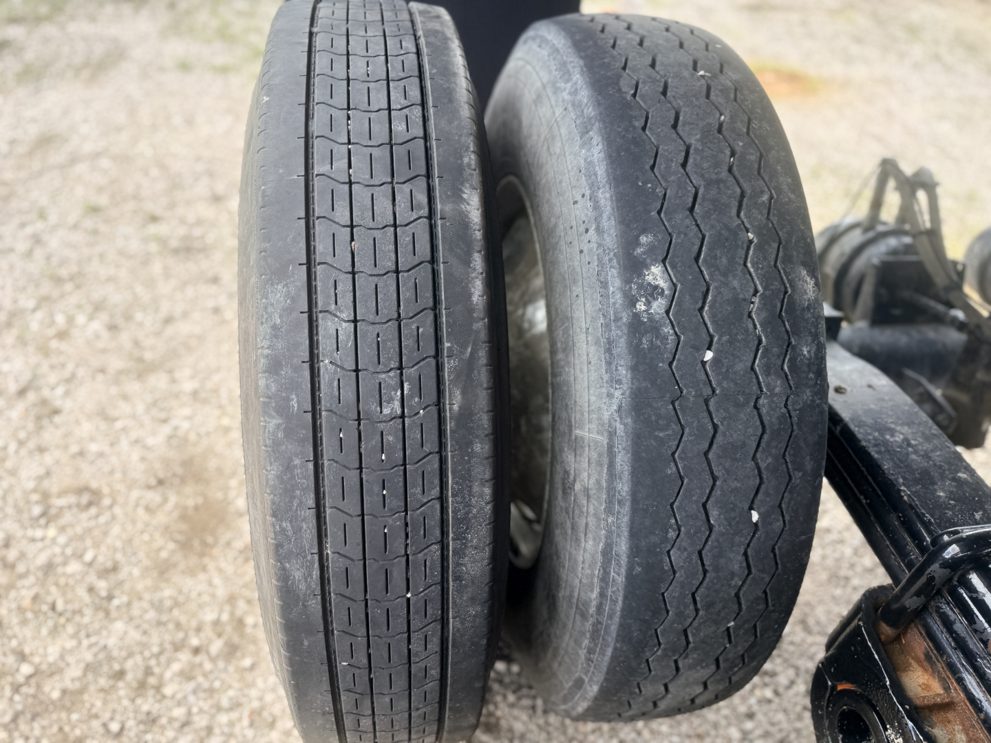Dual trailer wheels and tires on a dump trailer showing tread patterns and hub area.