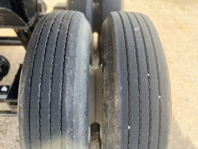Trailer axle dual tires with tread wear, viewed from above, showing two rear wheels.
