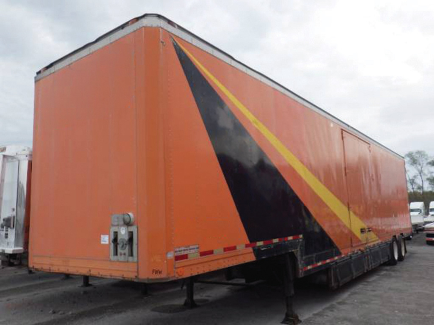 Aluminum drop frame furniture van showing side ramp and rear doors with orange paint and black/yellow diagonal stripe