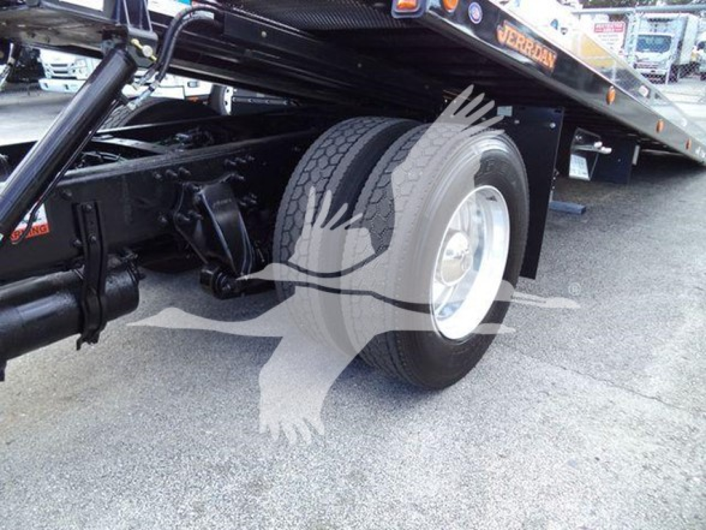 Freightliner Business Class M2 106 roll-back tow truck rear wheel and chassis visible with dual rear tires.