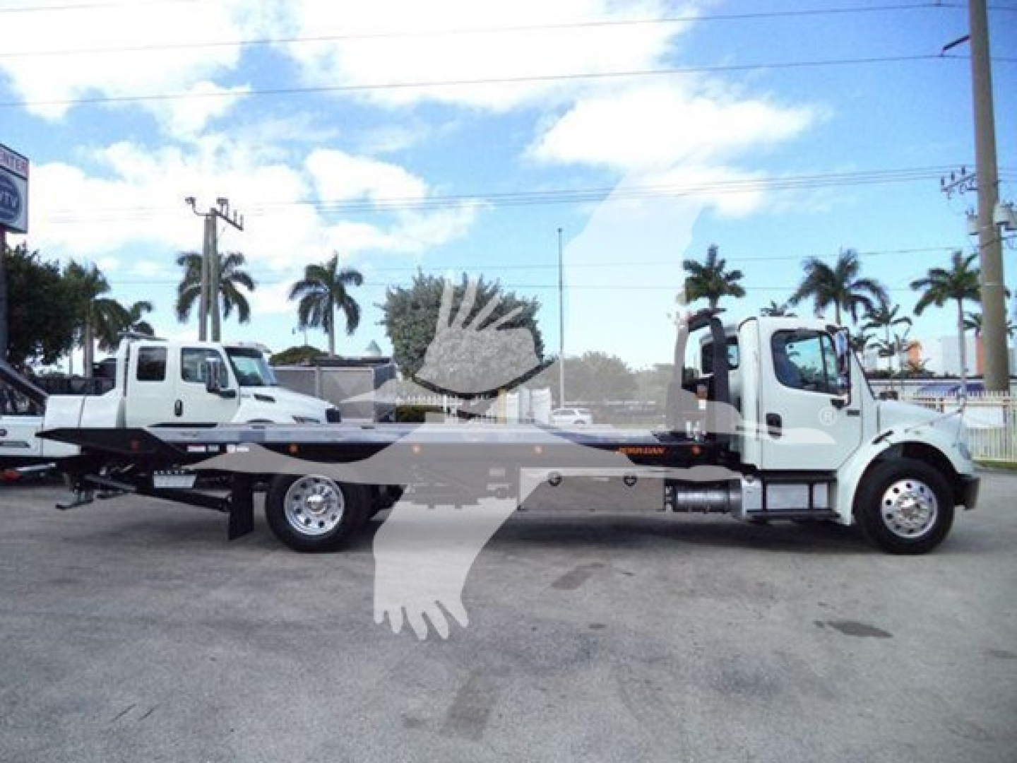 2019 Freightliner Business Class M2 106 rollback truck side view showing two white cab trucks connected by a flatbed