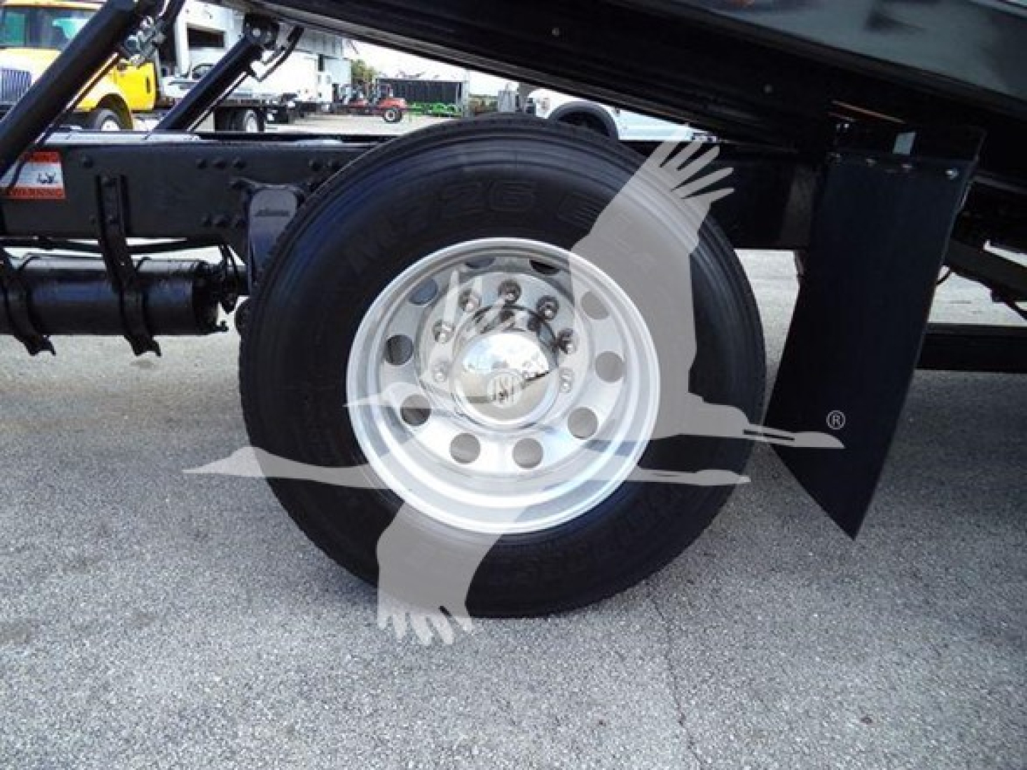 Freightliner Business Class M2 106 rear truck wheel and suspension, dual rear axle area, wheel with shiny silver rim.