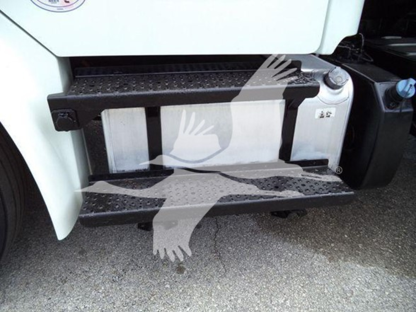 Truck side steps and fuel tank on Freightliner Business Class M2 106 with metal black steps and white cab