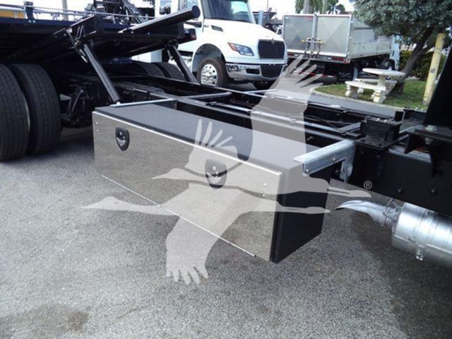 Freightliner M2 106 rollback truck chassis with a silver aluminum toolbox mounted under the cab and chrome fuel line. Visible text on toolbox not legible.