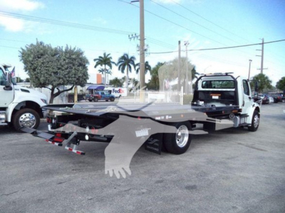 Freightliner Business Class M2 106 rollback truck with flatbed, side view showing rear hooks and light assembly.