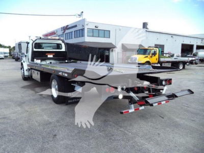 Freightliner Business Class M2 106 rollback truck showing flatbed bed with rear ramps.