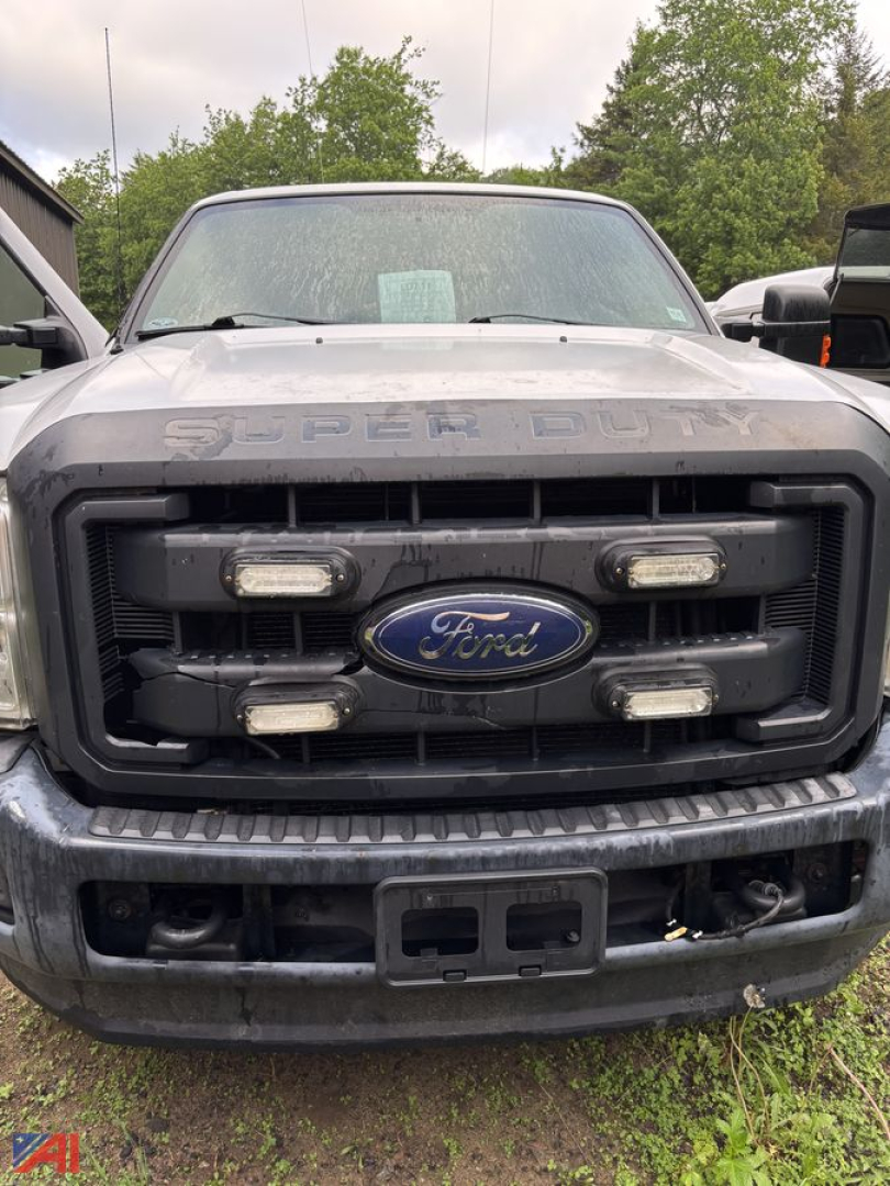 Front view of a 2016 Ford F-250 Super Duty pickup with a black grille, four auxiliary lights, and Ford emblem; dirt and mud on bumper; hood reads SUPER DUTY.