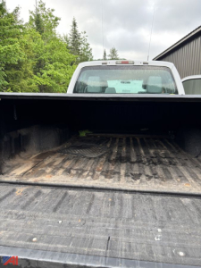 Truck bed of a 2016 Ford F-250 Super Duty crew cab pickup with tailgate down showing cargo bed with dirt and wear.