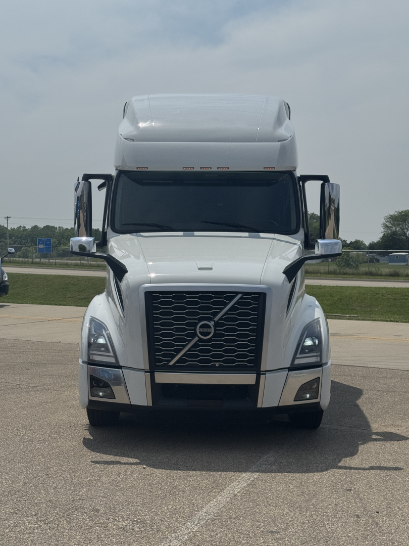 Front view of a white Volvo VNL truck with large grille, bumper, and mirrors. No text clearly legible on the vehicle surfaces.
