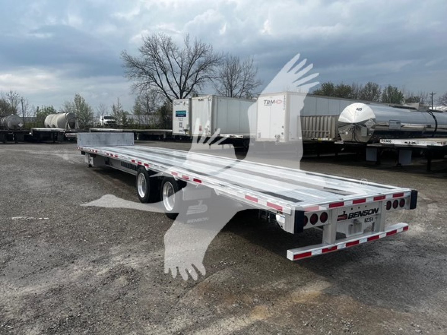 Transcraft aluminum drop deck trailer viewed from rear-left side showing dual axles and mud flaps.