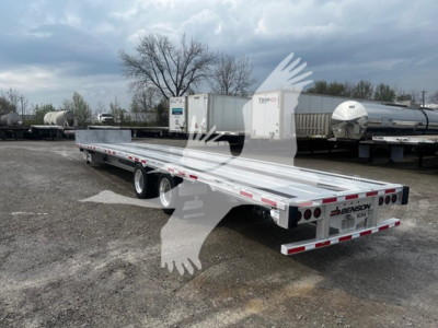 Transcraft aluminum drop deck trailer viewed from rear-left side showing dual axles and mud flaps.