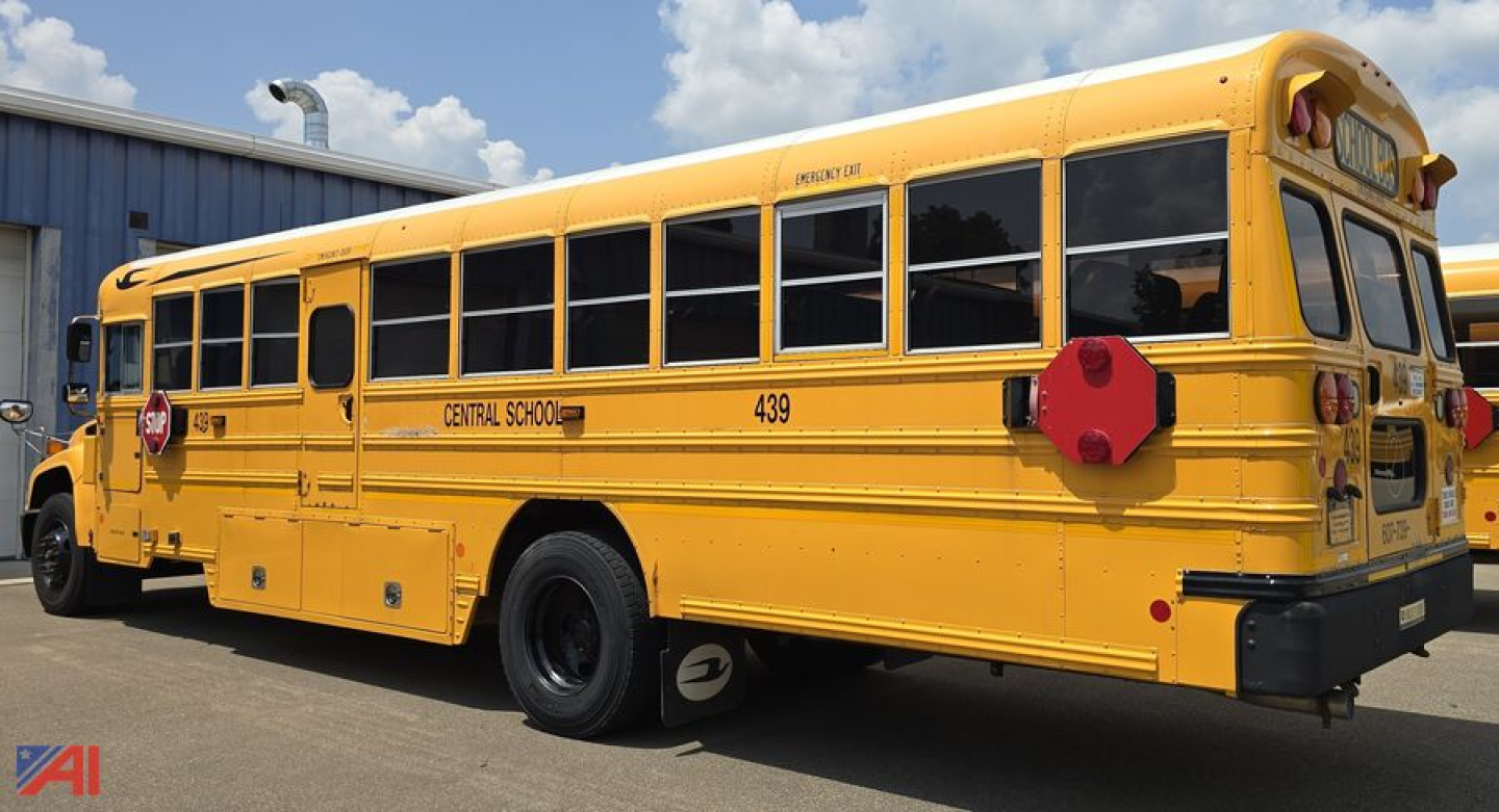 Blue Bird Vision school bus side and rear view showing yellow body, black windows, bus numbers 439 and CENTRAL SCHOOL, rear red hexagonal stop sign.