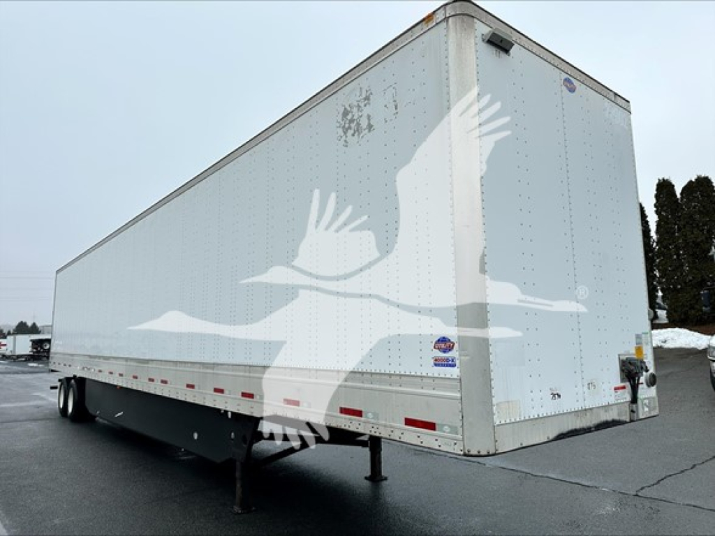 Utility trailer 4000D-X side/front view showing box cargo trailer with white exterior and wheel fenders.