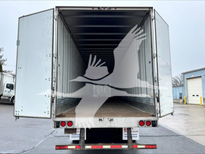Utility trailer interior view with open double doors showing empty cargo space