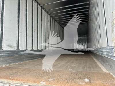 Inside a utility trailer with wooden floor and metal sidewalls; empty cargo area visible.