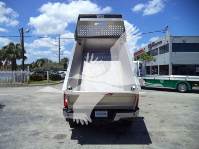 Rear view of a Volvo aluminum dump truck bed, with tailgate and interior, showing a back window and metal lattice guard on top.