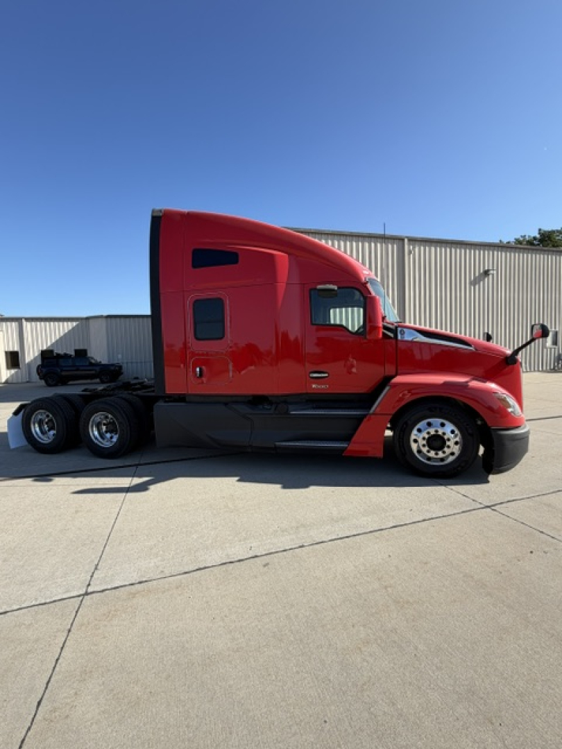Kenworth T680 tractor in red paint, side profile view showing cab and rear chassis with dual rear axles.