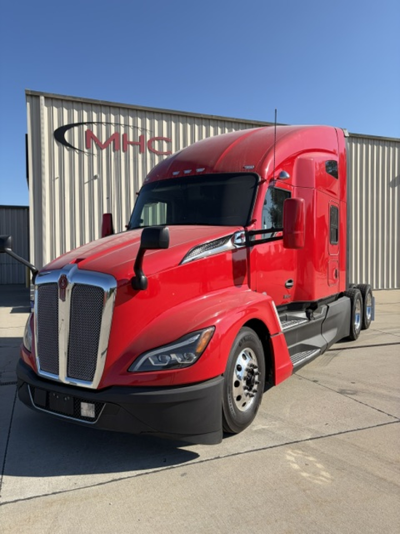 Kenworth T680 tractor unit in red, front-left view, with MHC building in background.