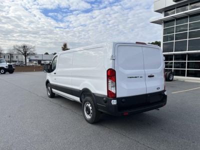 Ford Transit cargo van rear-right view showing cargo van with white paint, black bumper, and rear doors; Ford emblem on tailgate.