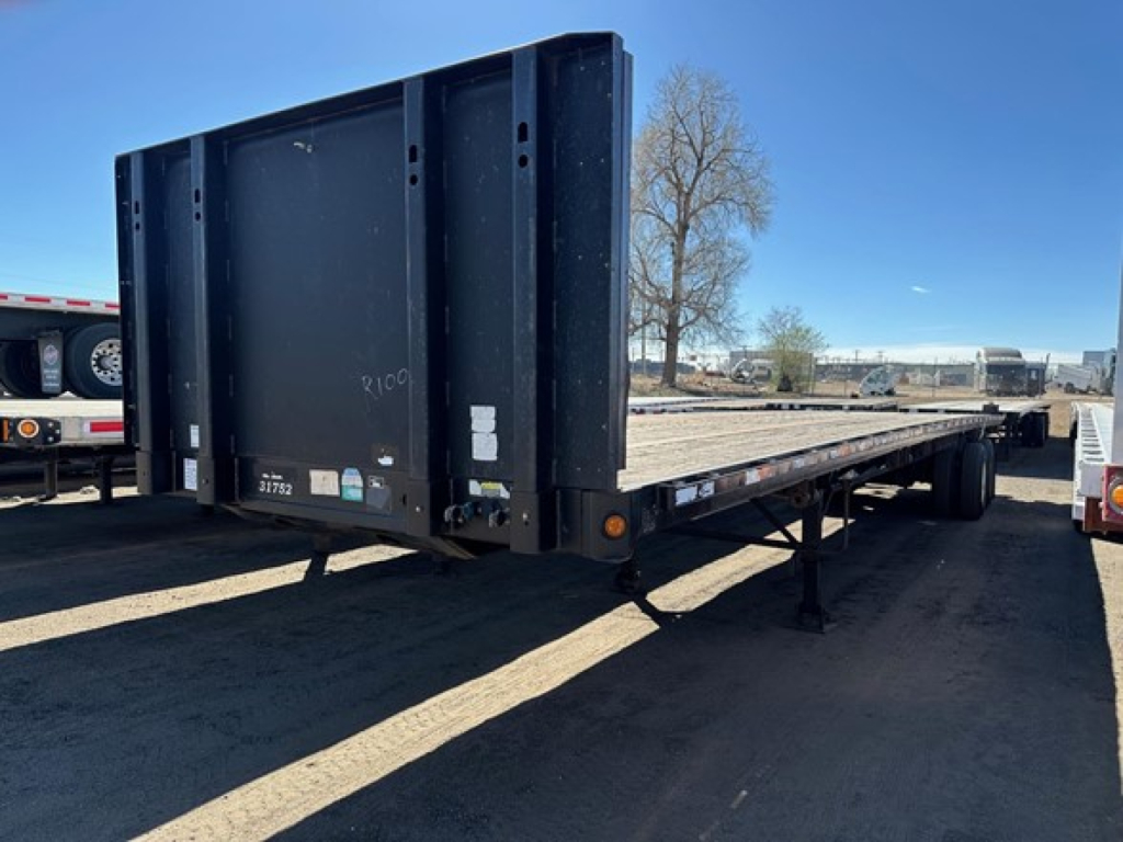 Direct Steel flatbed trailer showing rear end and long deck with support legs and reflective markers.