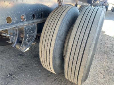 Direct Steel flatbed trailer showing dual rear tires with tread and part of the chassis frame