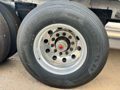 Hopper trailer wheel showing Hankook tire and chrome silver rim with red cap on hub.