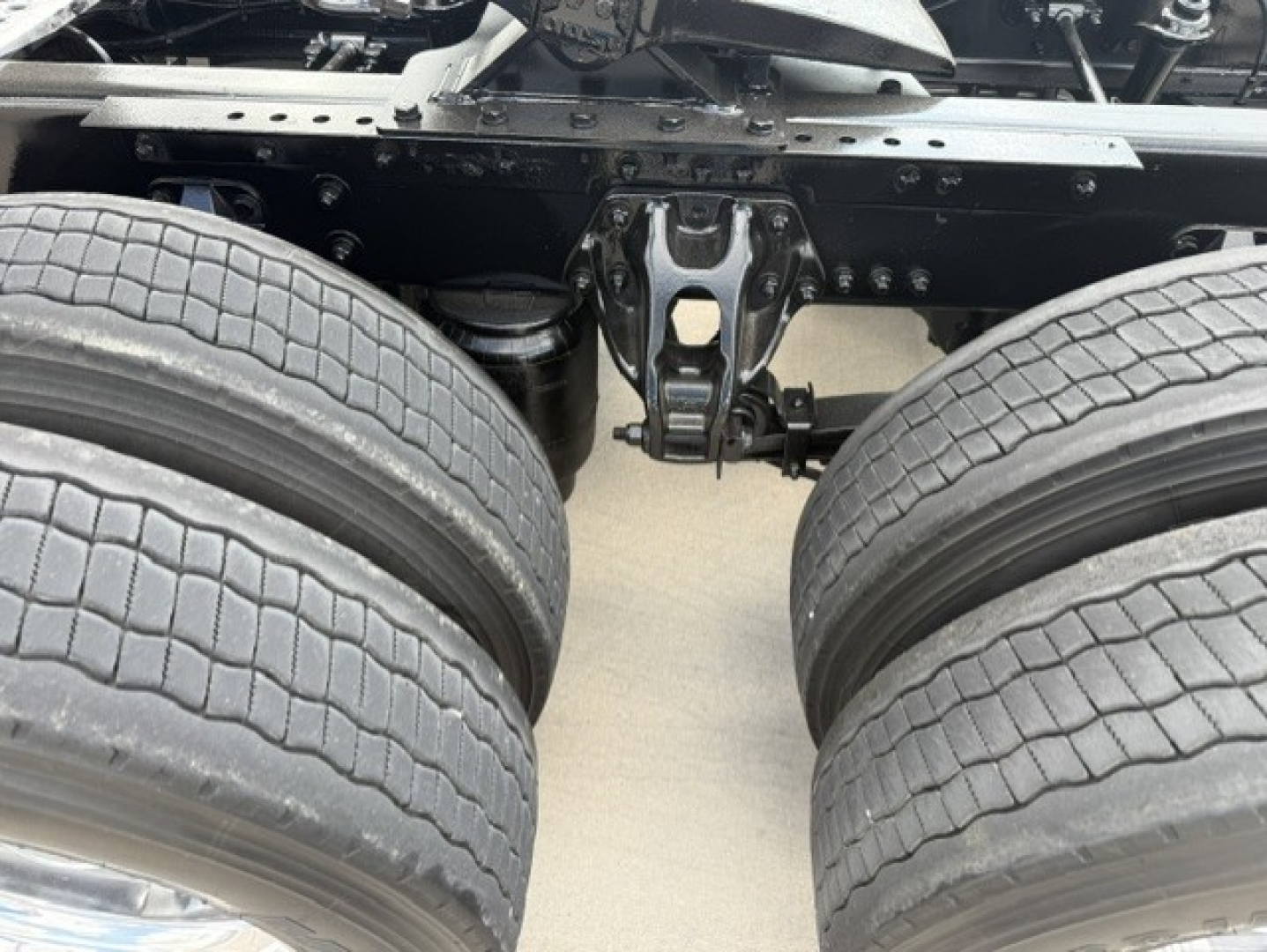 Kenworth T680 chassis with dual rear axles and fifth wheel mount visible; frame and suspension components; no cab shown.