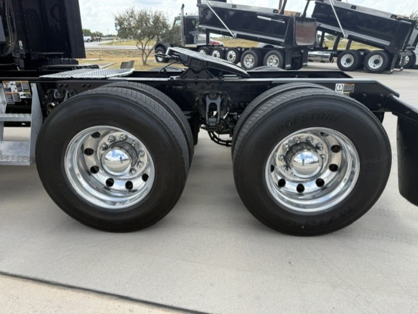 Dual rear wheels with chrome rims on a Kenworth T680 chassis showing Bridgestone tires.