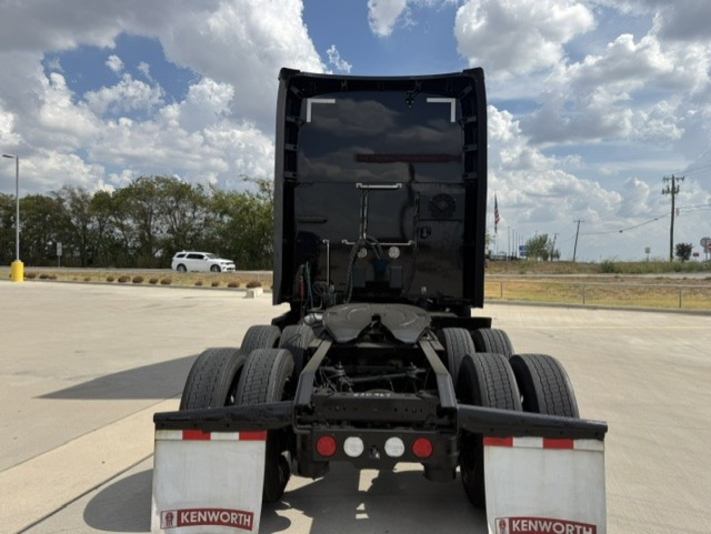 Kenworth T680 rear view showing fifth wheel area and dual rear axles with Kenworth mud flaps.