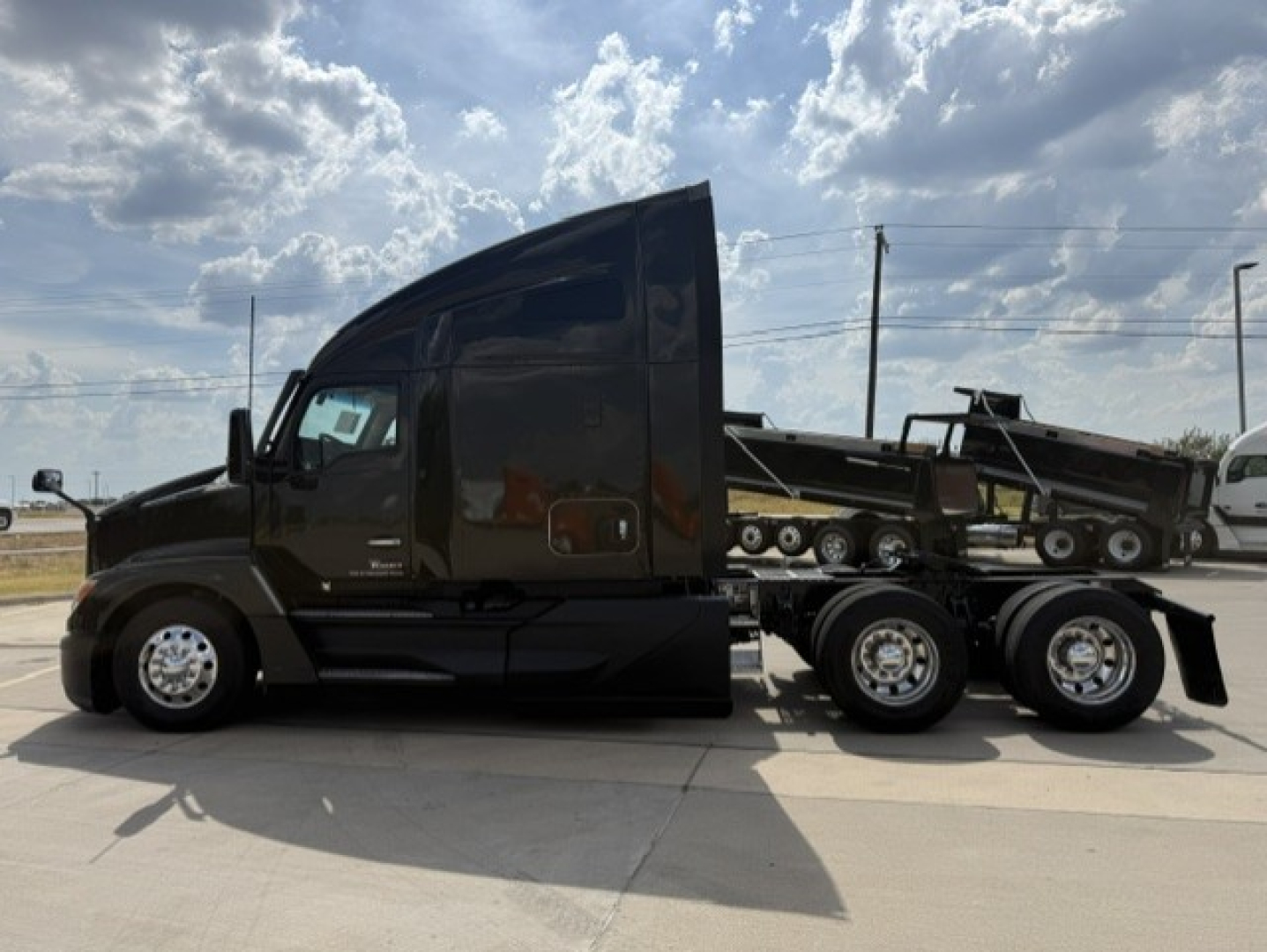 Kenworth T680 side view showing sleeper cab and black exterior.
