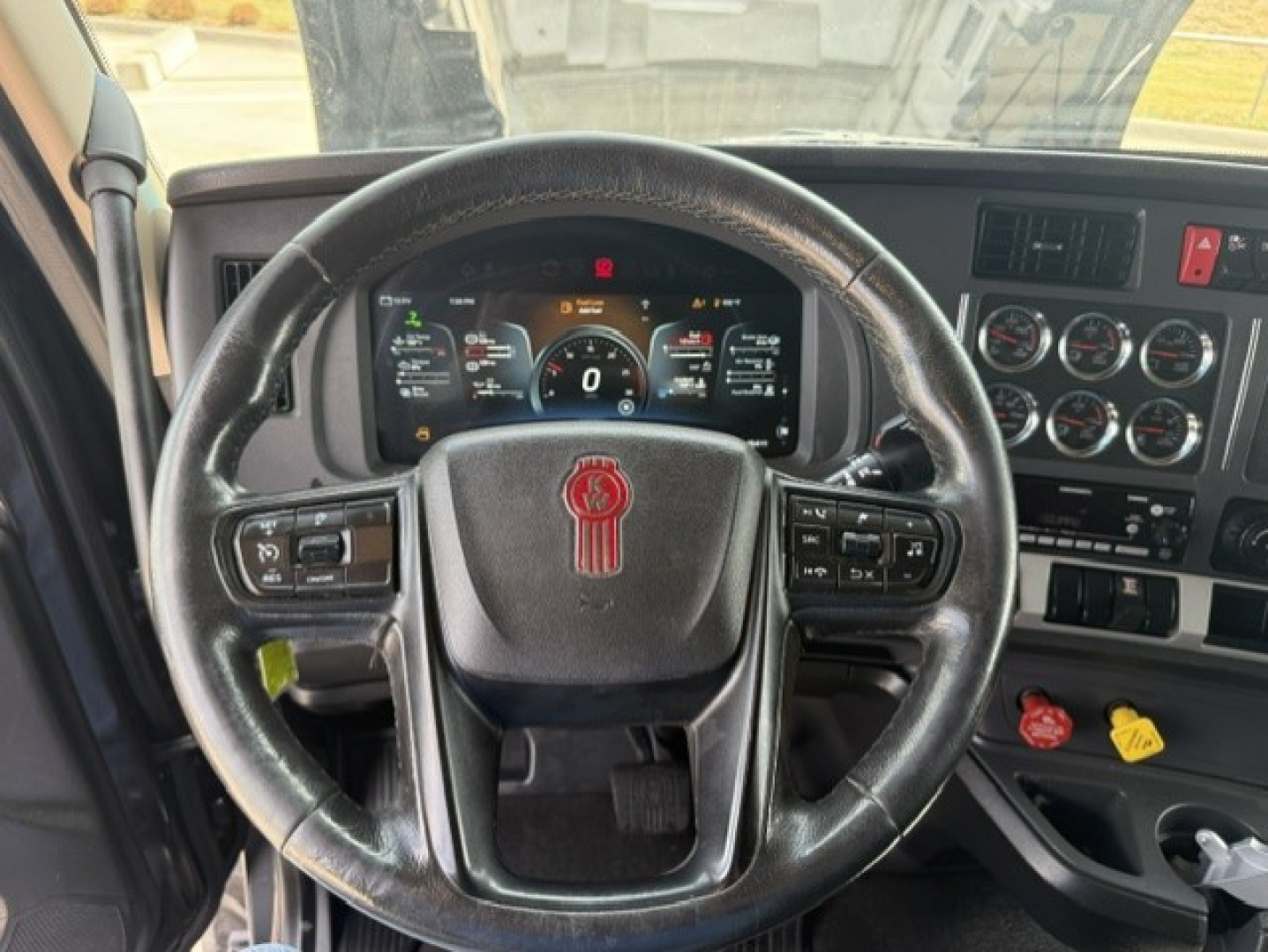 Kenworth T680 truck interior steering wheel with instrument cluster and dashboard controls visible.