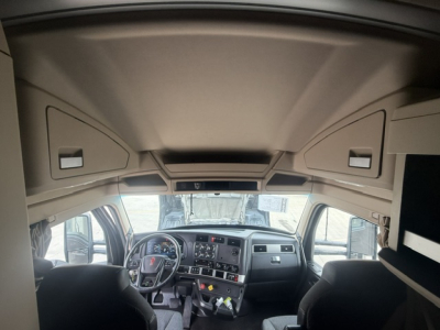Kenworth T680 truck cabin interior view with steering wheel, dashboard, and overhead storage compartments.