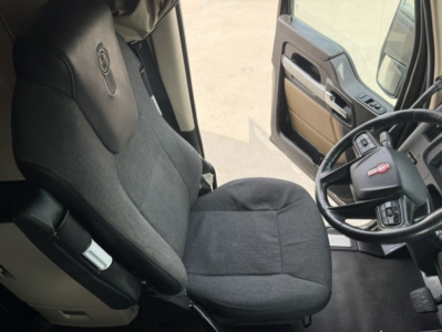 Truck cabin interior showing seat and steering wheel of a Kenworth T680 with Chevrolet logo on steering? No. Text not visible.