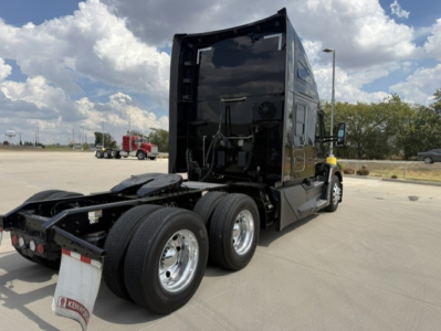 Kenworth T680 conventional sleeper tractor rear view with dual rear axles and black paint.