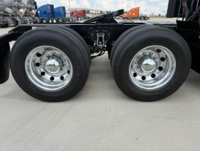 Kenworth T680 chassis dual rear wheels showing chrome rims and tire treads, frame rails and suspension components visible.
