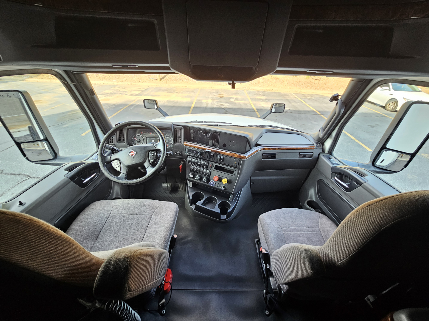 Interior cab view of a 2021 International LT625 truck showing dashboard, steering wheel, and seating from the driver’s perspective.