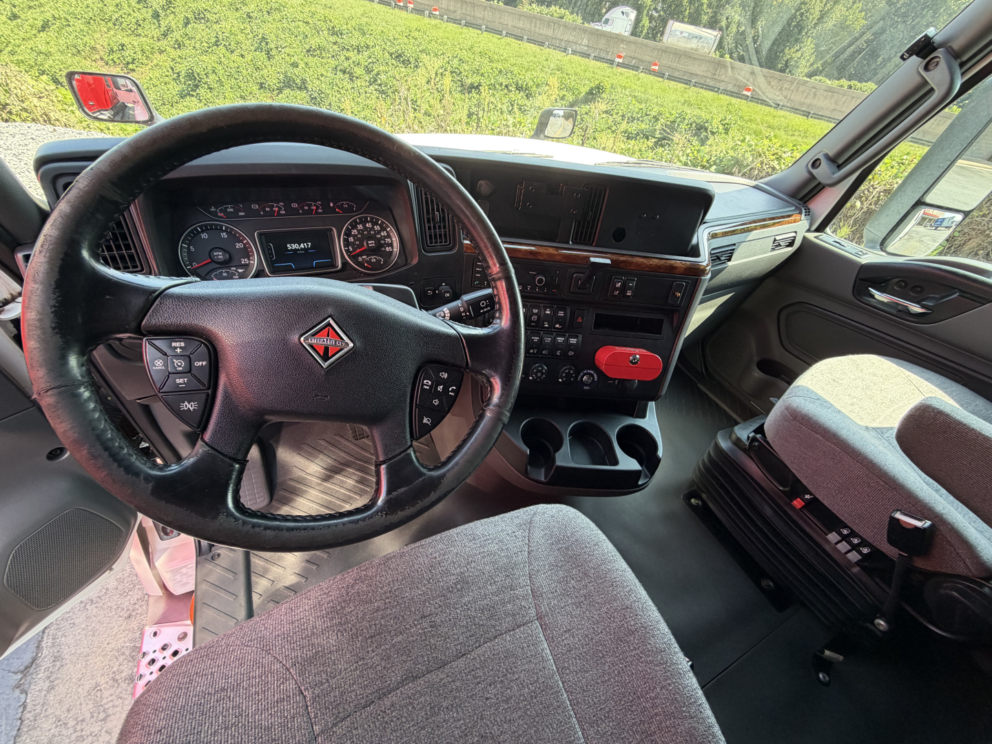 Interior view of a 2021 International LT625 truck cab showing steering wheel dashboard center console and gear shifter.