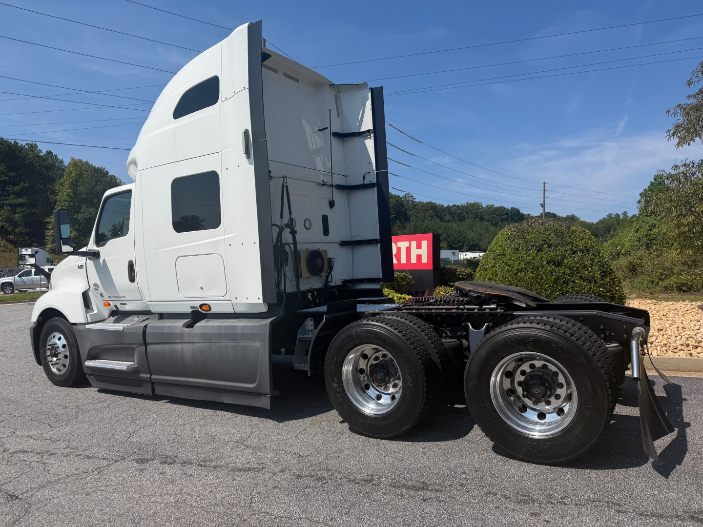 International LT625 sleeper cab tractor trailer side view showing rear dual wheels and fifth wheel coupling.