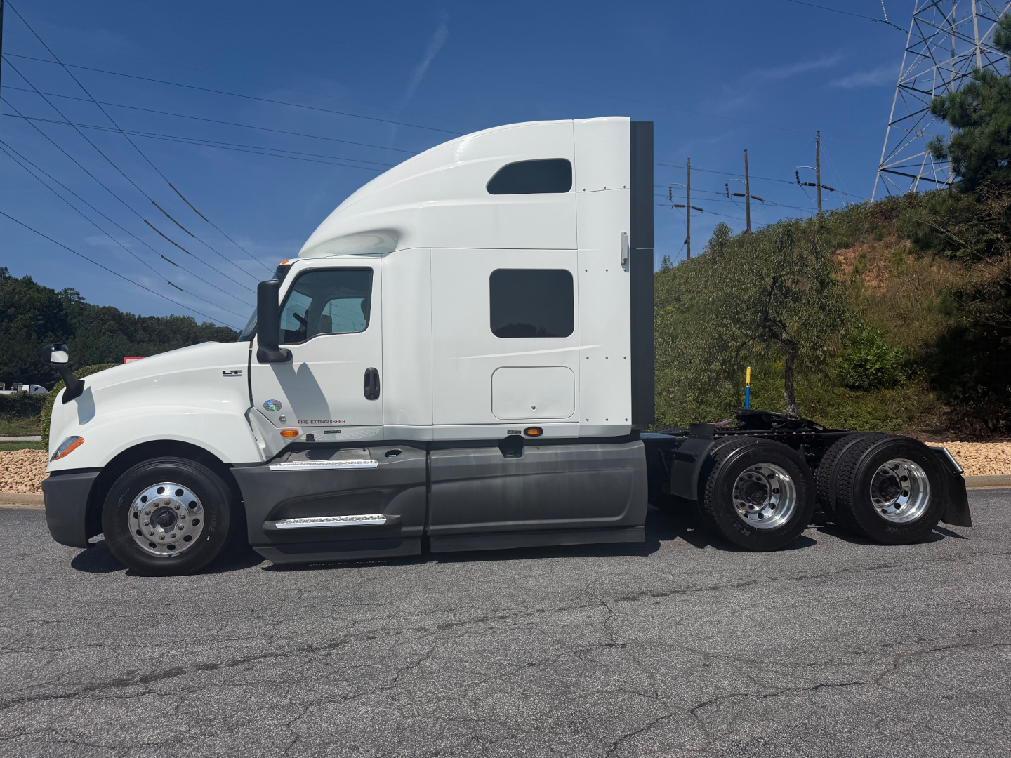 Coupe side view of 2021 International LT625 tractor with sleeper cab, white exterior, dual rear axles, no trailer.