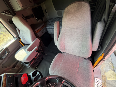 Interior cab of a 2021 International LT625 truck showing grey fabric seats, steering wheel, and driver area.
