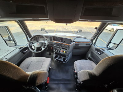 Interior cab view of a 2021 International LT625 truck showing dashboard, steering wheel, and seating from the driver’s perspective.