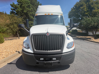 Front view of a white 2021 International LT625 truck with a large vertical grille, headlights, and bumper; no visible text on the grille.