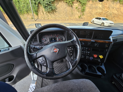 Interior of 2021 International LT625 truck showing steering wheel and dashboard with multiple controls and center console.