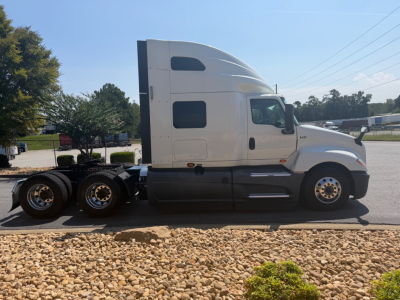 White International LT625 sleeper cab tractor in side profile view showing cab, fuel tanks, and rear axles.