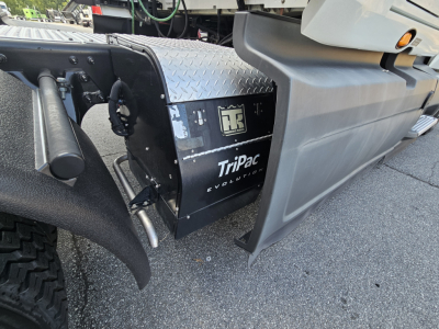 Truck component panel showing TriPac Evolution unit and diamond plate toolbox mounted between front wheel and cab on 2021 International LT625.