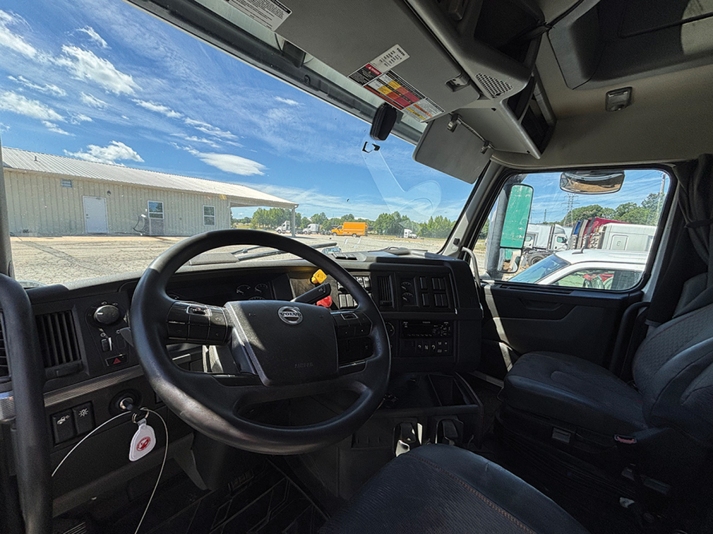 Cab interior of a 2021 Volvo VNL 860 showing steering wheel, dashboard, and seat. Visible text includes no legible labels beyond general components.