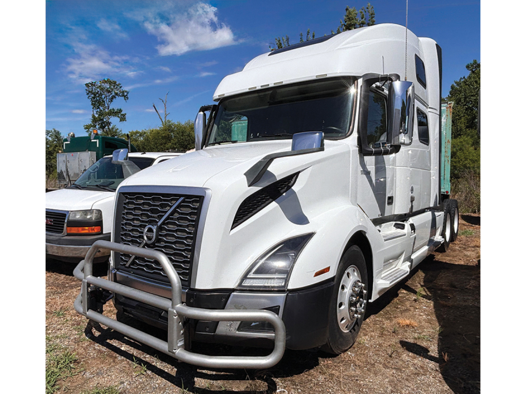 Volvo VNL 860 sleeper cab truck in white with front grille guard and chrome mirrors, front view.