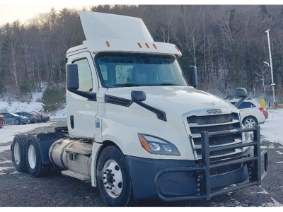 Front/side view of a white Freightliner Cascadia126 daycab tractor with a raised sleeper, black bull guard, and dual rear axles in a snowy lot.