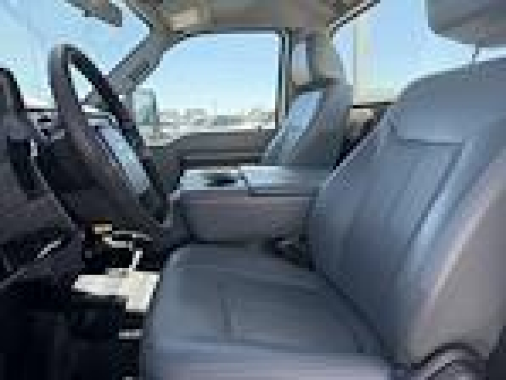 Ford F-250 interior front seats and dashboard view, light gray upholstery, steering wheel visible.